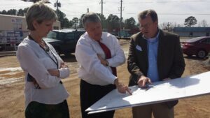 State Director John H. Magill, Architect Bell, and Susan Anderson review blueprints.